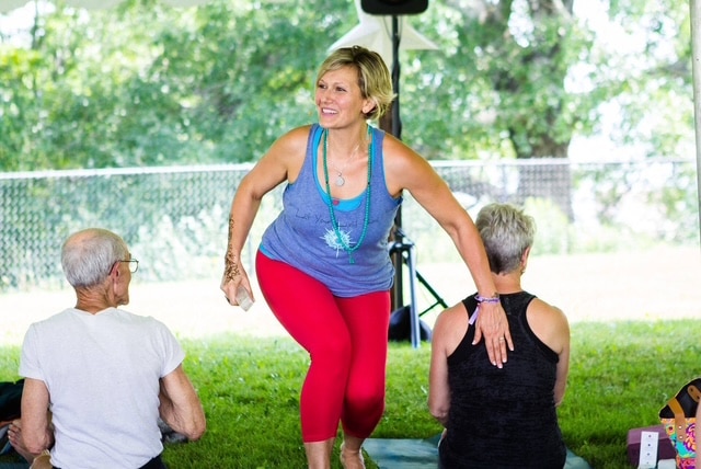 Melissa Boyd placing her hand on a student's back during a yoga class she is teaching